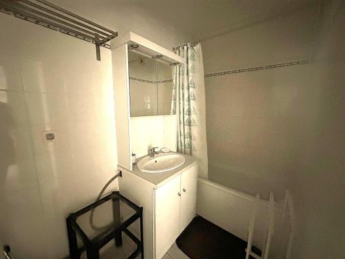 une salle de bain blanche avec un lavabo et un miroir dans l'établissement Charmant T2 avec loggia, proche plage, résidence avec piscine - FR-1-472-209, à Sète