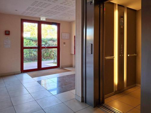 un couloir vide avec une porte et une fenêtre dans l'établissement Charmant cocon avec WiFi à Merville-Franceville-Plage - FR-1-788-59, à Merville-Franceville-Plage