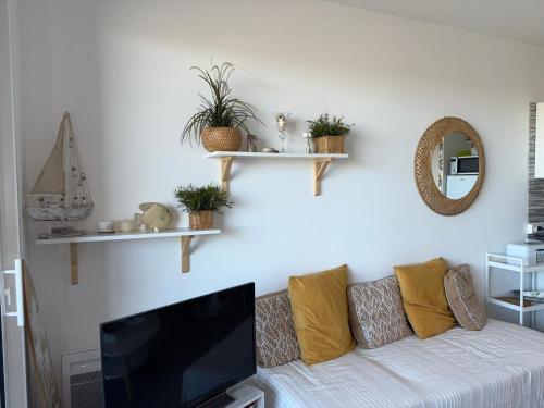 un salon avec un canapé et une télévision à écran plat dans l'établissement Appartement cosy avec vue mer, parking privé, 2 chambres - FR-1-323-569, à Saint-Hilaire-de-Riez