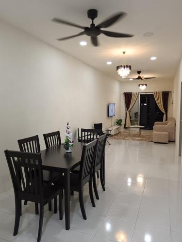 a dining room and living room with a table and chairs at Aleesa Homestay in Tapah