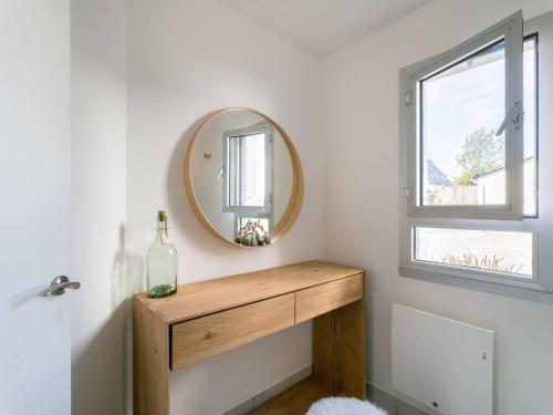 La salle de bains est pourvue d'un miroir et d'une table en bois. dans l'établissement Carnac : Appartement 2 pièces avec parking, proche plage - FR-1-477-256, à Carnac