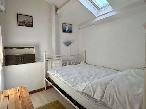 un lit blanc dans une chambre avec une fenêtre dans l'établissement Argelès - Appartement 2 pièces pour 4 personnes, piscine - FR-1-225-828, à Argelès-sur-Mer