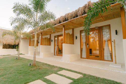 a villa with a thatched roof and a yard at LEUX Hotel Alona Panglao in Panglao