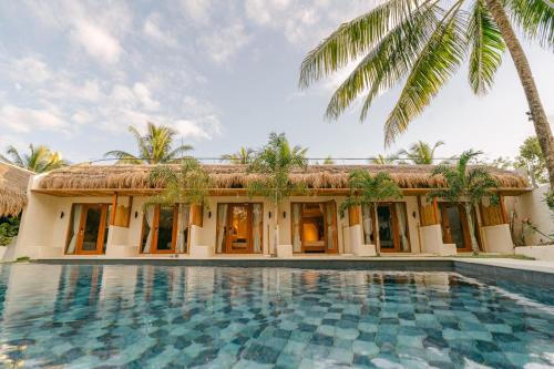 a villa with a swimming pool in front of a house at LEUX Hotel Alona Panglao in Panglao