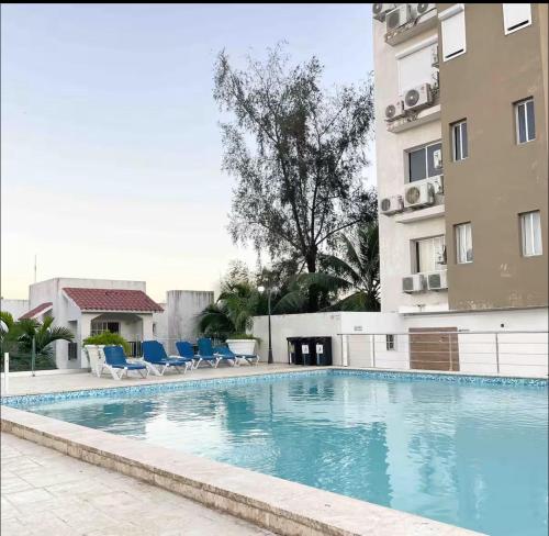 a swimming pool in front of a building at Apartamento boca chica in Andrés