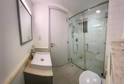a bathroom with a shower and a sink and a toilet at Sifah Poolside Paradise in Muscat