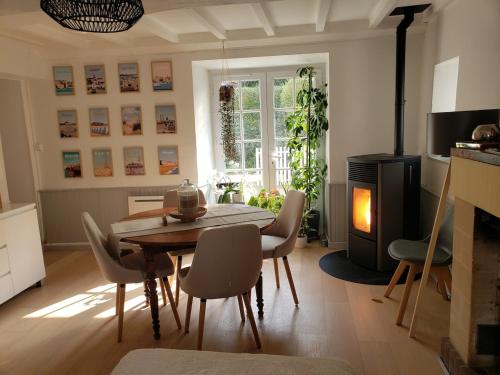 un salon avec une table et des chaises et une cheminée dans l'établissement Maison de charme avec terrasse, à Ver-sur-Mer