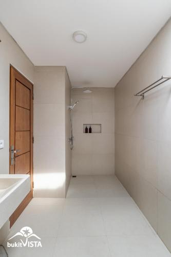 a bathroom with a shower and a sink at Kubu Mesari Homestay by Bukit Vista in Canggu