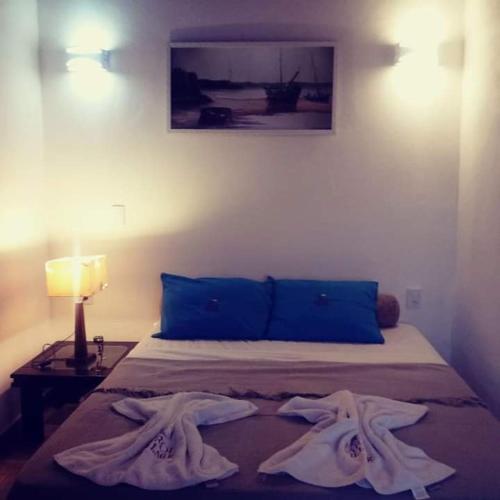 a bedroom with a bed with two robes on it at Chalés Farol Village in Fortim