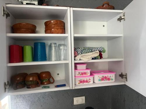 a kitchen pantry with white shelves with items on them at Casa de campo in Cuautla Morelos