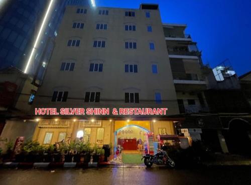 a hotel with a sign in front of a building at Hotel Selver Shinn & Restaurant in Phnom Penh
