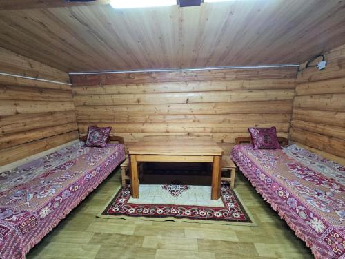 KhyaktilにあるNelly's Guest House and Community-led toursのログキャビン内のベッド2台が備わる部屋です。