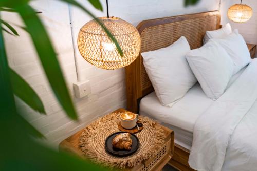 a bed with a table with a cup of coffee on it at Eden Garden Villa Canggu in Canggu