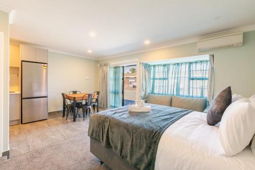 a bedroom with a bed and a table and a kitchen at Lavana Motel in Hastings
