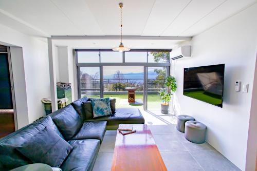 a living room with a couch and a tv at 真鶴町ペットと泊まれてBBQも可能な広々ワンフロア貸切apartment Hotel途乃中RC1 in Manazuru