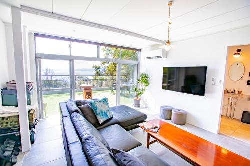 a living room with a couch and a table at 真鶴町ペットと泊まれてBBQも可能な広々ワンフロア貸切apartment Hotel途乃中RC1 in Manazuru