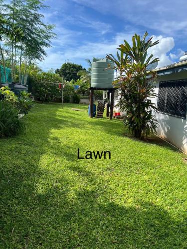 a yard with a lawn with a house at Family Home in Nadi in Nadi