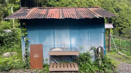 a small blue shack with a sink in it at 古民家ウェルネスビレッジ青梅 成木の社 Nariki no Mori in Ome