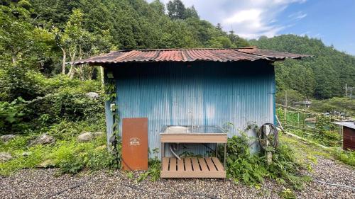 a blue shack with a table in front of it at 古民家ウェルネスビレッジ青梅 成木の社 Nariki no Mori in Ome
