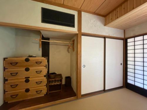 a room with a chest of drawers and a window at 古民家ウェルネスビレッジ青梅 成木の社 Nariki no Mori in Ome