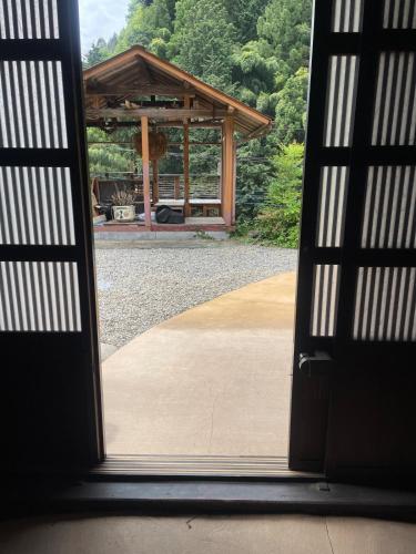 an open door with a pavilion in the background at 古民家ウェルネスビレッジ青梅 成木の社 Nariki no Mori in Ome