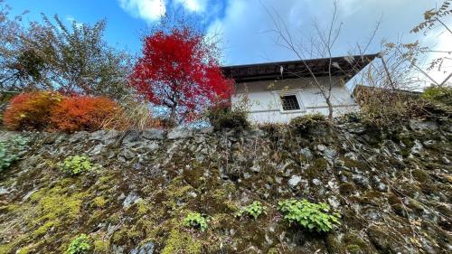 a house on top of a rocky hill at 古民家ウェルネスビレッジ青梅 成木の社 Nariki no Mori in Ome
