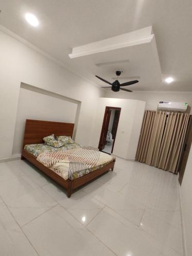 a bedroom with a bed and a ceiling fan at Mehmood Palace in Lahore