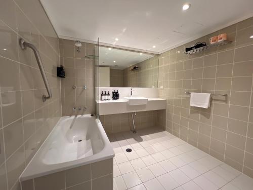 a bathroom with a tub and a sink and a shower at Serain Chatswood Central in Sydney
