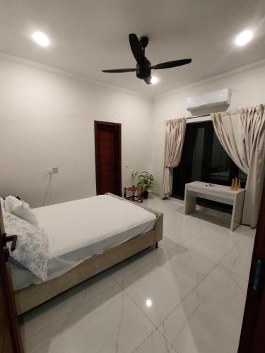a bedroom with a bed and a ceiling fan at Mehmood Palace in Lahore