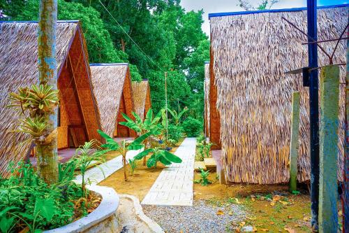 an outdoor garden with wooden huts and plants at Ciudad Caliente by The Lavana in Talisay