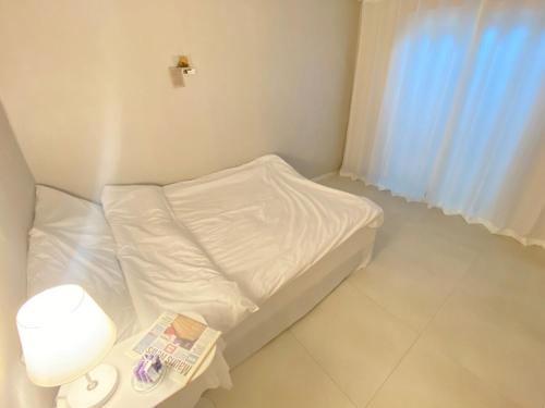 a small white bed in a room with a window at Ban Stay in Daegu