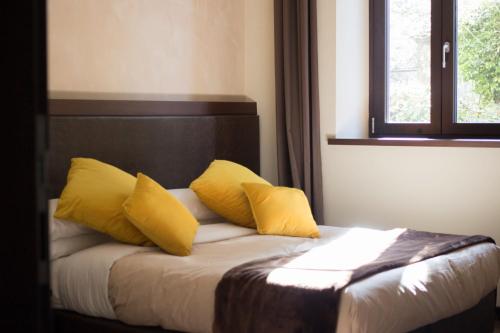 a bedroom with a bed with yellow pillows on it at Arena Luxury Rooms in Verona
