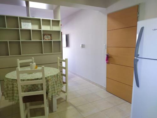 a kitchen with a table and a refrigerator at Alquiler Temporario Tucumán Con Cochera Y Pileta in San Miguel de Tucumán