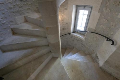 a spiral staircase in a building with a window at Château Pellisson in Cognac