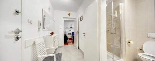 a white bathroom with a shower and a toilet at Apartment Osijek-Tvrda in Osijek