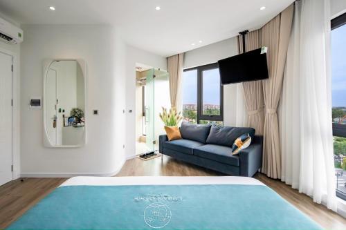 a bedroom with a blue bed and a couch at Urban Oasis Villa & Chill in Ðình Loan