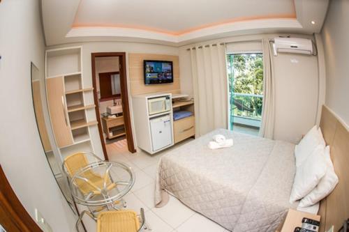 a small room with a bed and a television at Pousada Cristalmar in Bombinhas