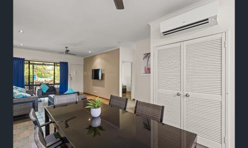 a dining room with a table and chairs and a living room at Broome - 2 Bedroom Apartment in Cable Beach