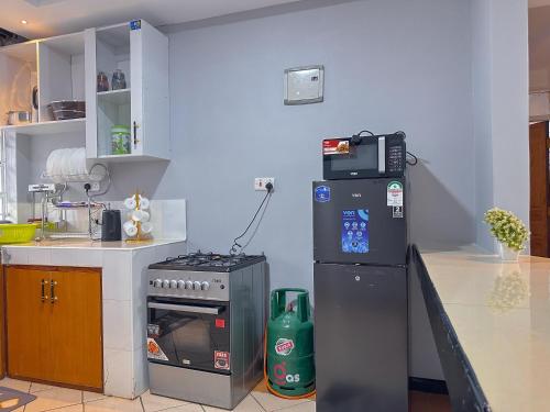 a kitchen with a stove and a refrigerator at Normad homes in Kisii