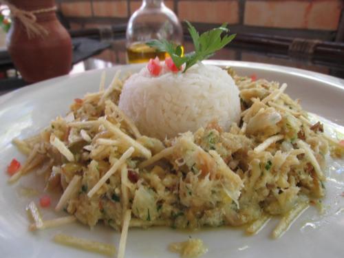 a white plate of food with rice and meat at Hotel Enseada Maracajaú in Maracajaú