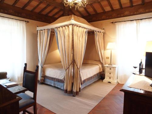 a bedroom with a canopy bed in a room with windows at Relais Todini in Collevalenza