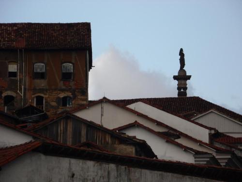 a view of roofs with a building in the background at Varanda Pouso e Arte in Ouro Preto