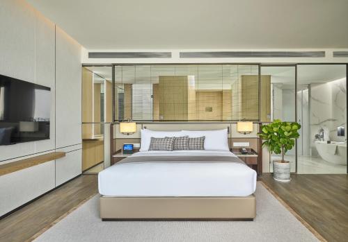 a bedroom with a large bed and a bathroom at Grand Ocean View Hotel Zhuhai in Zhuhai
