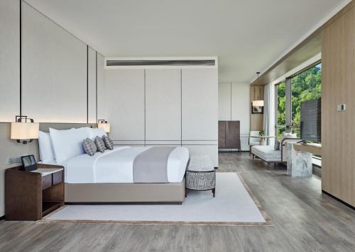 a bedroom with a bed and a living room at Grand Ocean View Hotel Zhuhai in Zhuhai