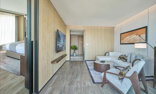 a living room with a couch and a bed at Grand Ocean View Hotel Zhuhai in Zhuhai