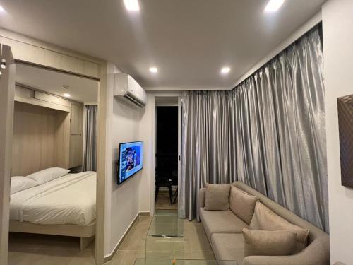 a bedroom with a bed and a couch in a room at City Garden Olympus- 606 & 818 in Pattaya South