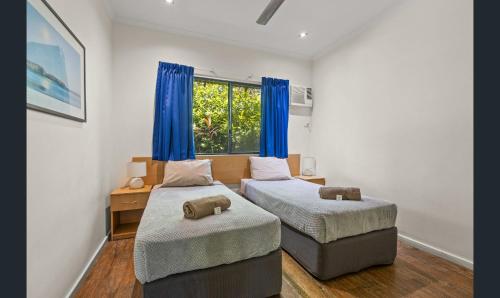 a bedroom with two beds and a window at Broome - 2 Bedroom Apartment in Cable Beach