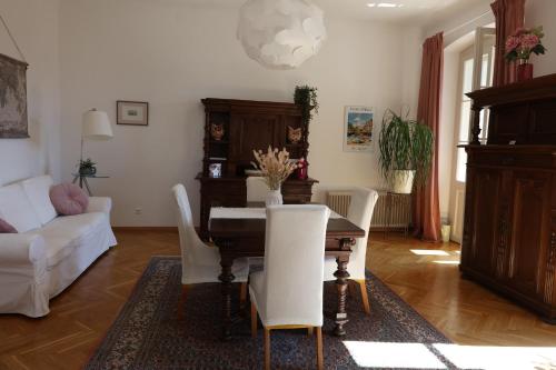 a living room with a table and white chairs at Villa Adrienne in Velden am Wörthersee