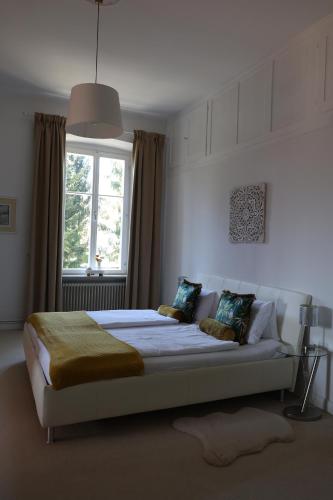 a bedroom with a large bed with a window at Villa Adrienne in Velden am Wörthersee