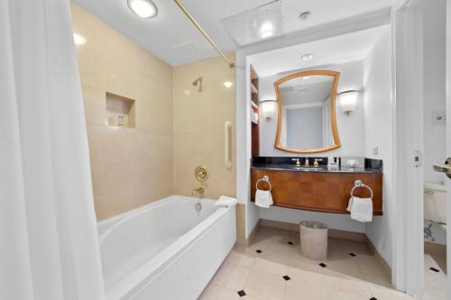 a bathroom with a tub and a sink and a mirror at Beachfront 1BR 2BA Condo CozySuites at Showboat in Atlantic City